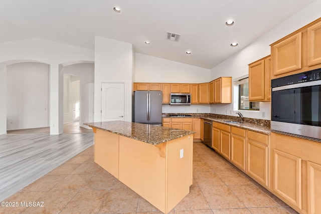 11874 N Verismo Dr, Tucson, AZ 85737 - kitchen featuring appliances with stainless steel finishes, a kitchen island, a sink, arched walkways, and recessed lighting