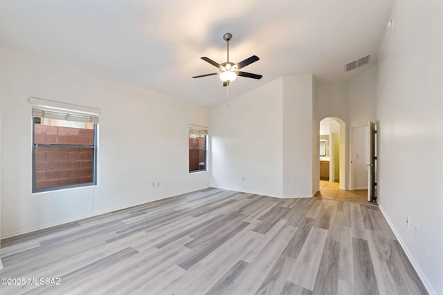 11874 N Verismo Dr, Tucson, AZ 85737 - unfurnished room with ceiling fan, arched walkways, light wood-style floors, and baseboards
