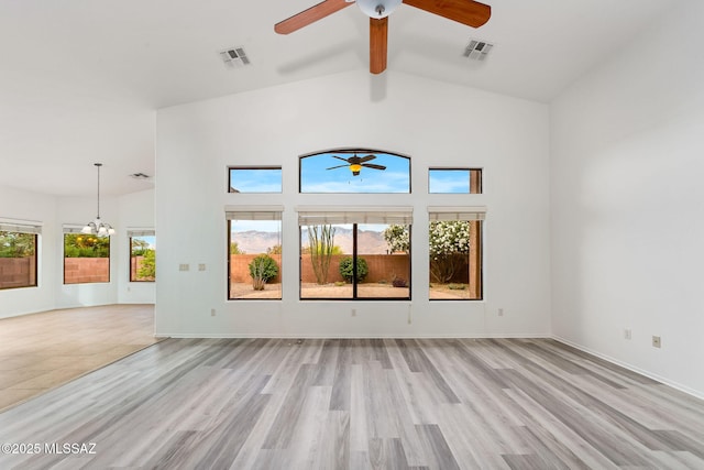 11874 N Verismo Dr, Tucson, AZ 85737 - empty room with a ceiling fan, beamed ceiling, light wood-style floors, a chandelier, and high vaulted ceiling