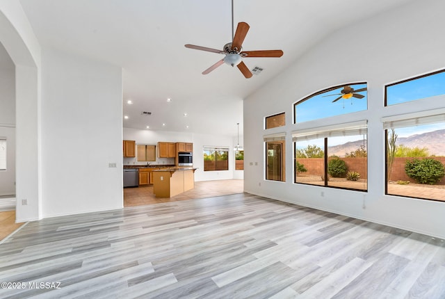 11874 N Verismo Dr, Tucson, AZ 85737 - unfurnished living room featuring a ceiling fan, light wood-type flooring, high vaulted ceiling, arched walkways, and recessed lighting