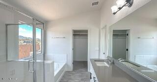 full bathroom featuring a garden tub, vaulted ceiling, and double vanity