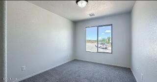 unfurnished room with carpet and baseboards
