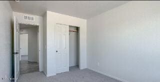 unfurnished bedroom with a closet, carpet flooring, and baseboards