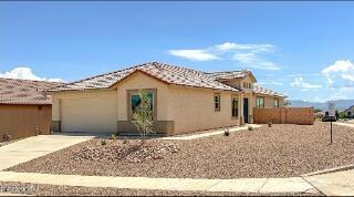 ranch-style house featuring concrete driveway, stucco siding, and a garage