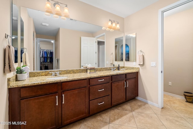 5950 S Hoptree Pl, Tucson, AZ 85747 - full bathroom with double vanity, tile patterned floors, a walk in closet, and baseboards