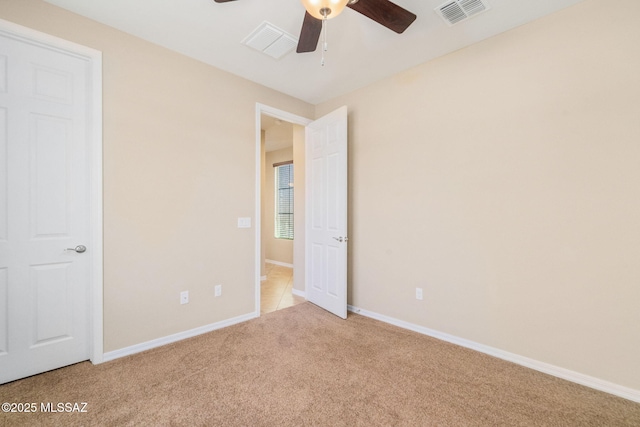 5950 S Hoptree Pl, Tucson, AZ 85747 - unfurnished bedroom featuring light carpet, baseboards, and a ceiling fan