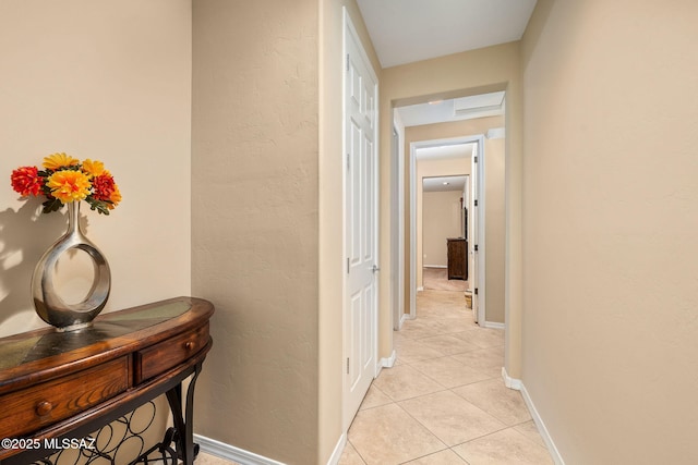 5950 S Hoptree Pl, Tucson, AZ 85747 - hallway with light tile patterned flooring, baseboards, and a textured wall