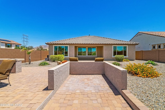 5950 S Hoptree Pl, Tucson, AZ 85747 - back of property featuring stucco siding, a tiled roof, a fenced backyard, and a patio