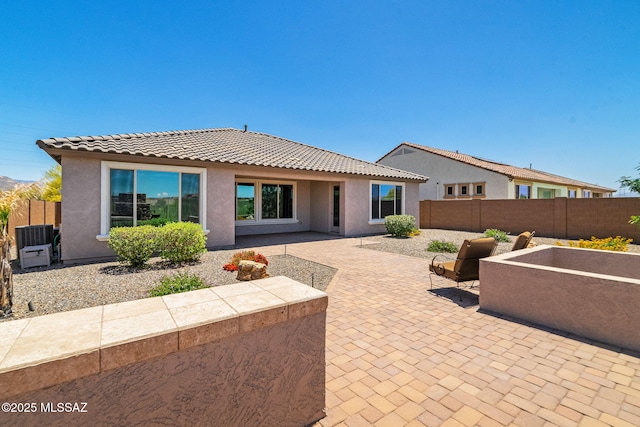 5950 S Hoptree Pl, Tucson, AZ 85747 - rear view of house featuring a tiled roof, a fenced backyard, stucco siding, and a patio