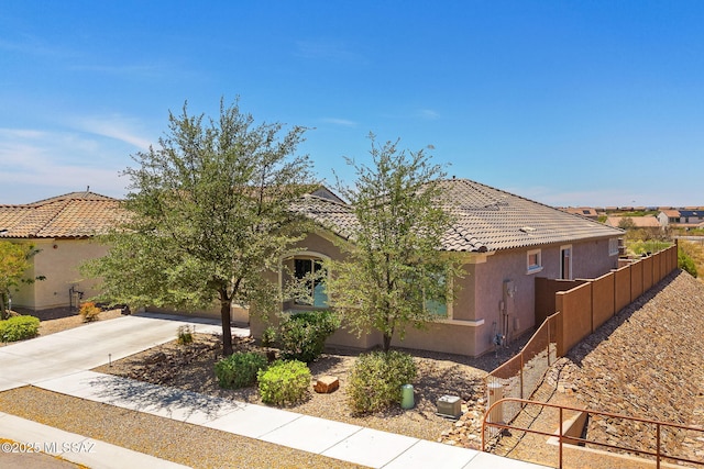 5950 S Hoptree Pl, Tucson, AZ 85747 - view of front facade with stucco siding, fence, and a tiled roof