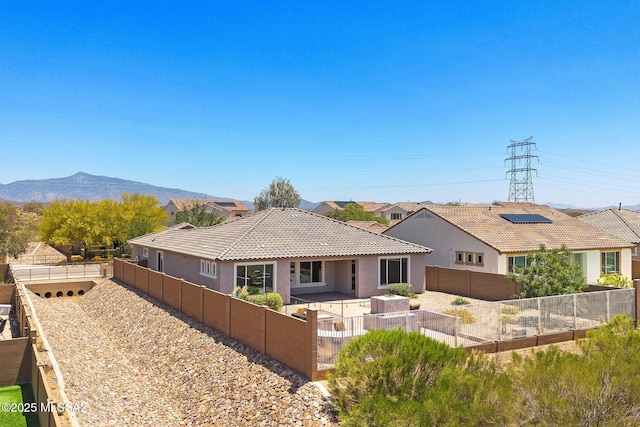 5950 S Hoptree Pl, Tucson, AZ 85747 - rear view of house featuring a fenced backyard, stucco siding, a vegetable garden, a tile roof, and a mountain view