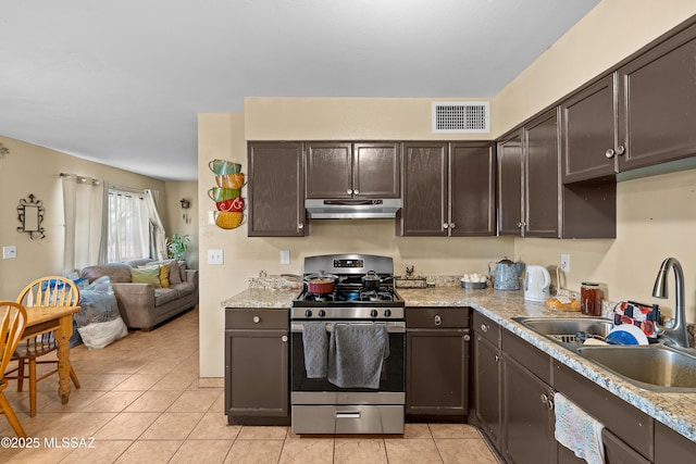 4760 W Tumacacori Dr, Amado, AZ 85645 - kitchen featuring gas range, a sink, under cabinet range hood, and dark brown cabinetry