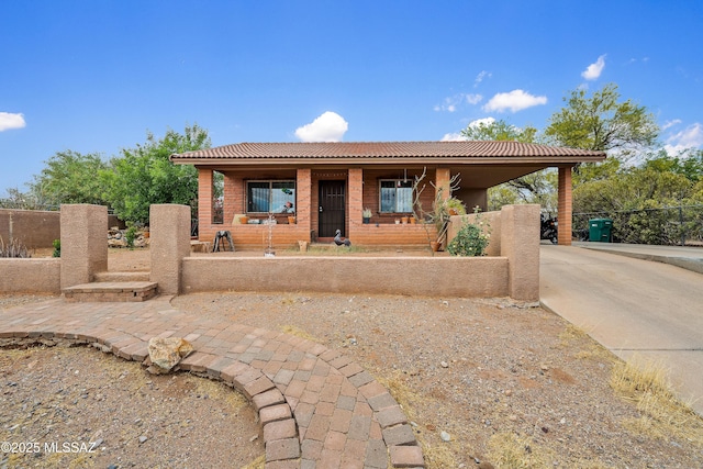 4760 W Tumacacori Dr, Amado, AZ 85645 - view of front of home featuring driveway, a porch, fence, a tiled roof, and a carport