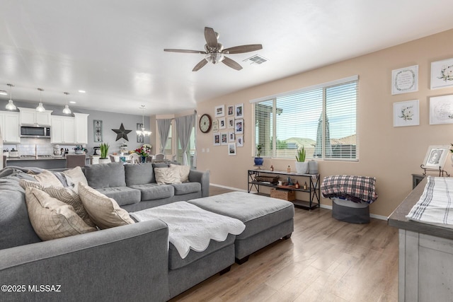 14247 E Axle Dr, Vail, AZ 85641 - living room featuring ceiling fan, light wood-style floors, baseboards, recessed lighting, and a chandelier