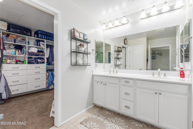 14247 E Axle Dr, Vail, AZ 85641 - bathroom featuring double vanity, baseboards, a spacious closet, and tile patterned floors