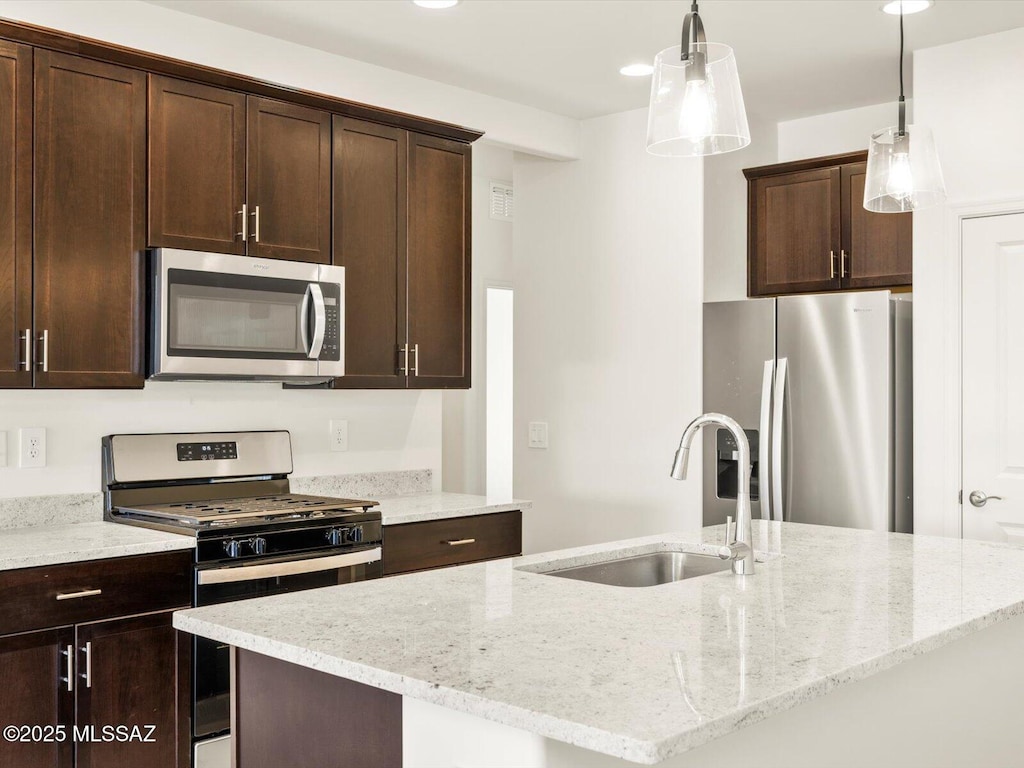 4710 E Julian Wash Dr, Tucson, AZ 85706 - kitchen featuring stainless steel appliances, a sink, dark brown cabinets, a center island with sink, and recessed lighting