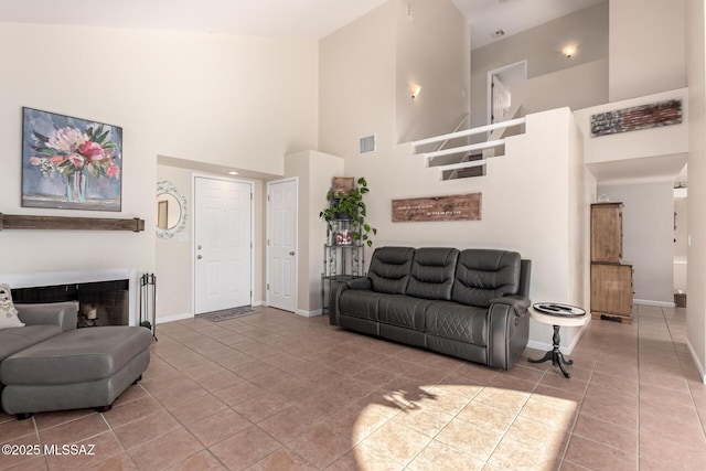 681 W Mountain Ridge Dr, Oro Valley, AZ 85737 - living room with a towering ceiling, tile patterned floors, baseboards, and a fireplace