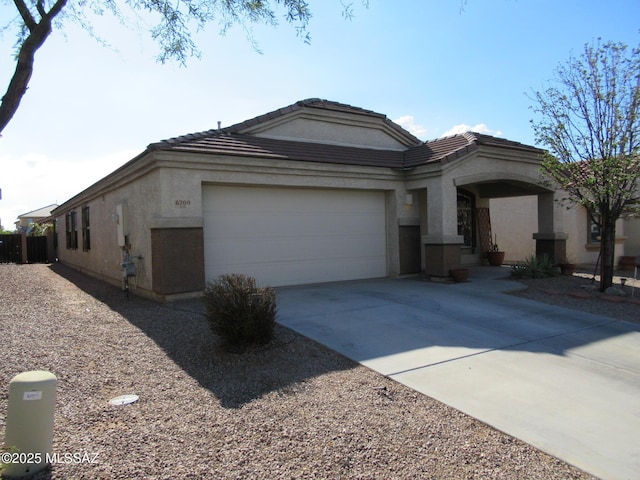 6700 S Stone Fly Dr, Tucson, AZ 85757 - view of front facade with an attached garage, concrete driveway, stucco siding, and a tile roof