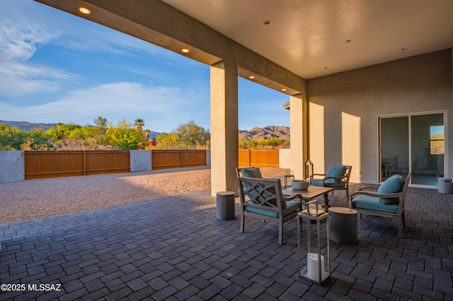 view of patio featuring a fenced backyard, an outdoor living space, and a mountain view