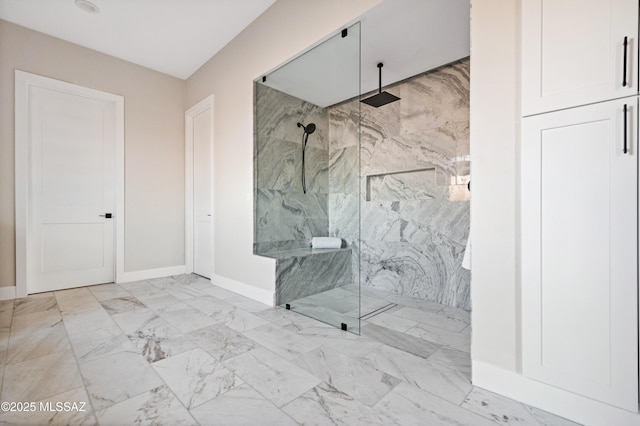 full bath with baseboards, a marble finish shower, and marble finish floors