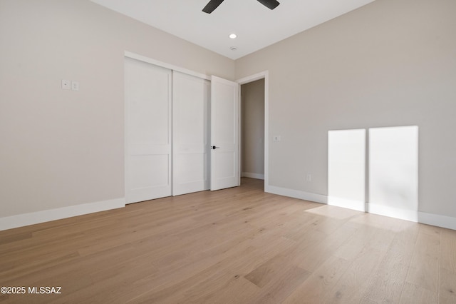 unfurnished bedroom with light wood finished floors, baseboards, a closet, and recessed lighting