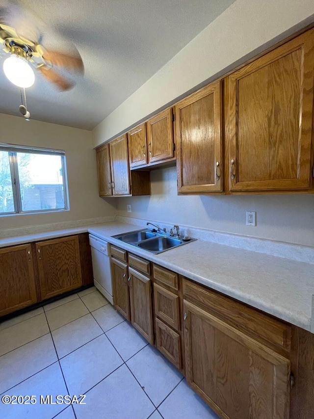 3873 N Pasatiempo Pl, Tucson, AZ 85705 - kitchen with a sink, dishwasher, brown cabinets, light tile patterned floors, and a textured ceiling