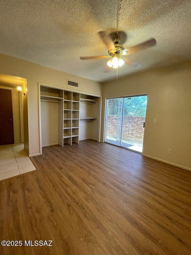 3873 N Pasatiempo Pl, Tucson, AZ 85705 - unfurnished bedroom with wood finished floors, a textured ceiling, baseboards, and ceiling fan