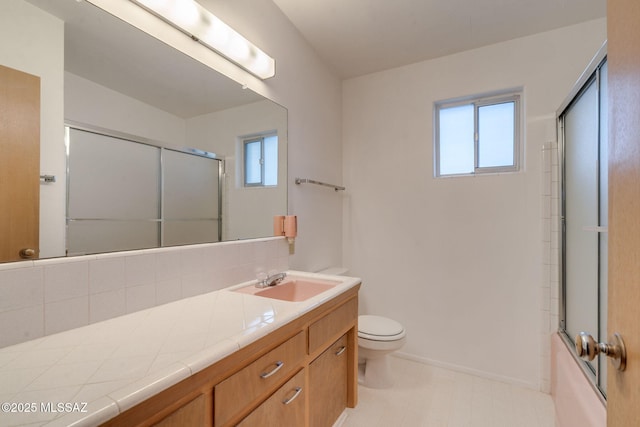 5301 E 4th St, Tucson, AZ 85711 - full bathroom with vanity, toilet, baseboards, bath / shower combo with glass door, and tile patterned floors