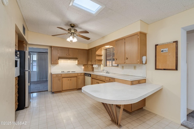 5301 E 4th St, Tucson, AZ 85711 - kitchen with stainless steel appliances, light countertops, a sink, and under cabinet range hood