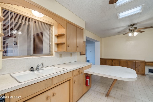 5301 E 4th St, Tucson, AZ 85711 - kitchen featuring a sink, light countertops, light brown cabinets, light tile patterned flooring, and a skylight
