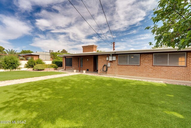 5301 E 4th St, Tucson, AZ 85711 - ranch-style house with a chimney, brick siding, and a front lawn