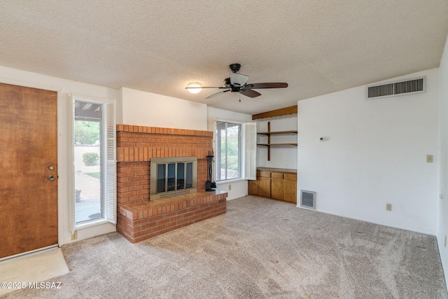 5301 E 4th St, Tucson, AZ 85711 - unfurnished living room featuring ceiling fan, carpet, a brick fireplace, and a textured ceiling