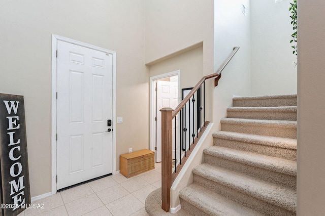 10487 S Cutting Horse Dr, Vail, AZ 85641 - entrance foyer featuring light tile patterned floors, stairway, a towering ceiling, and baseboards