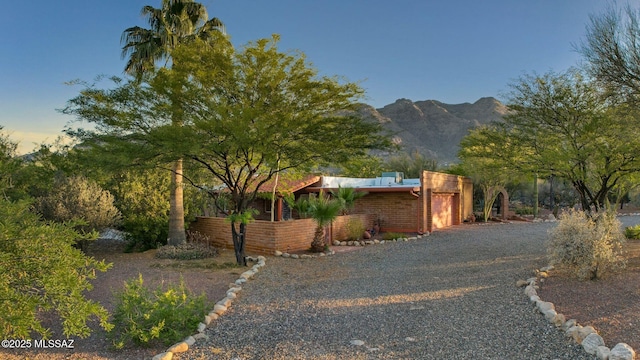 4921 E Camino De Los Olivos, Tucson, AZ 85718 - view of front of house with brick siding, a mountain view, an attached garage, and driveway