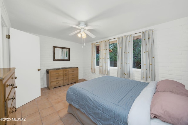 4921 E Camino De Los Olivos, Tucson, AZ 85718 - bedroom with light tile patterned flooring, a ceiling fan, and brick wall
