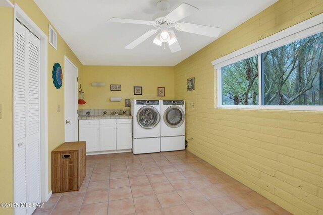 4921 E Camino De Los Olivos, Tucson, AZ 85718 - laundry room featuring washer and dryer, cabinet space, ceiling fan, light tile patterned floors, and brick wall