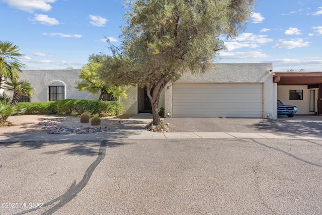 9350 E Speedway Blvd Unit 6, Tucson, AZ 85710 - view of front of home featuring stucco siding, a garage, and driveway