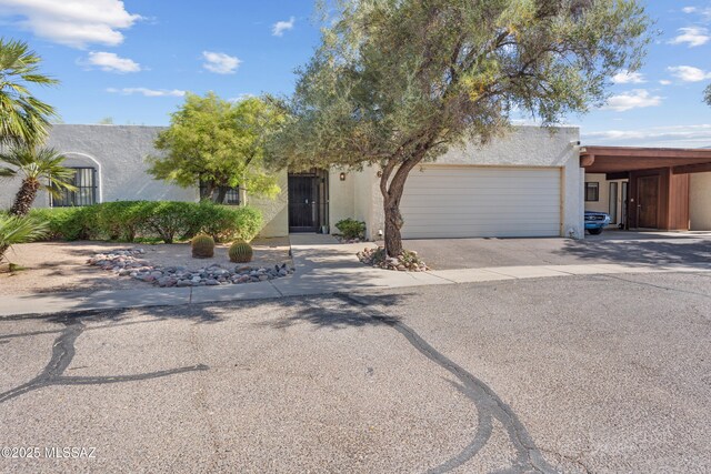 9350 E Speedway Blvd Unit 6, Tucson, AZ 85710 - view of front of home with stucco siding, driveway, and an attached garage
