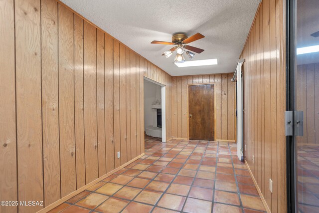 9350 E Speedway Blvd Unit 6, Tucson, AZ 85710 - hallway with a textured ceiling, wood walls, and baseboards