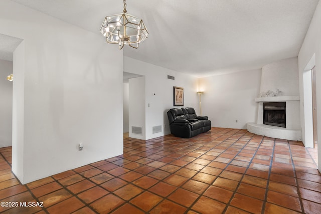 9350 E Speedway Blvd Unit 6, Tucson, AZ 85710 - unfurnished living room with a chandelier and a fireplace with raised hearth