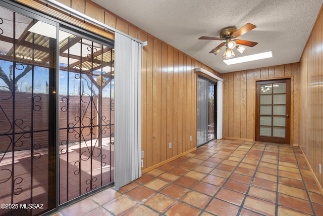 9350 E Speedway Blvd Unit 6, Tucson, AZ 85710 - entryway featuring ceiling fan, baseboards, wooden walls, and a textured ceiling
