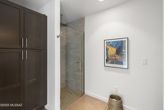 full bathroom featuring a stall shower and baseboards