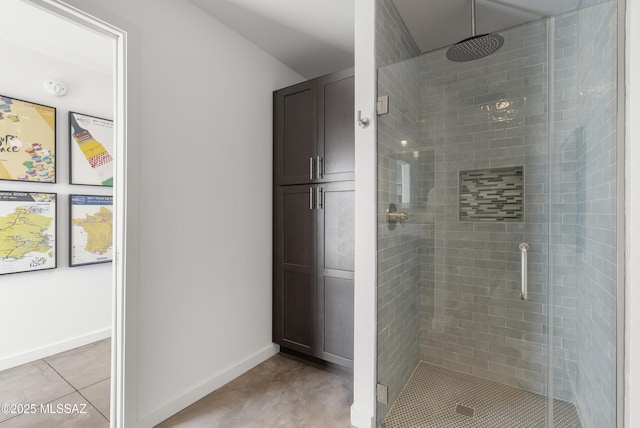 full bath with a stall shower, baseboards, and tile patterned flooring