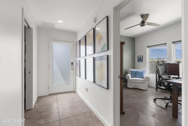 doorway to outside with baseboards, an office area, and a ceiling fan