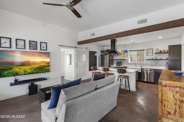 living room with a barn door, concrete floors, a ceiling fan, and recessed lighting