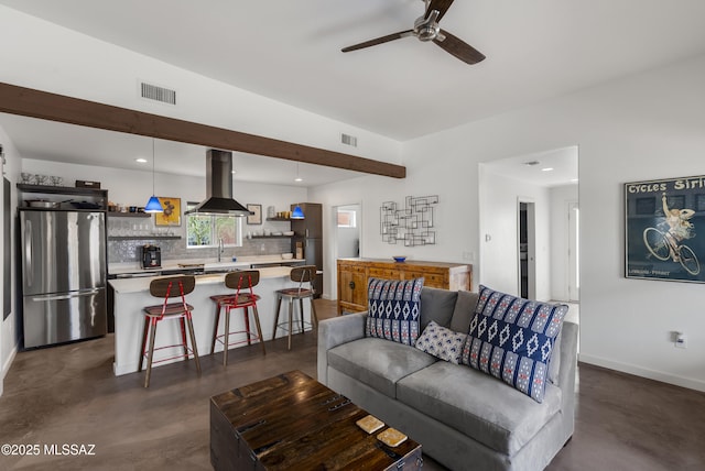 living area with finished concrete flooring, ceiling fan, baseboards, and recessed lighting