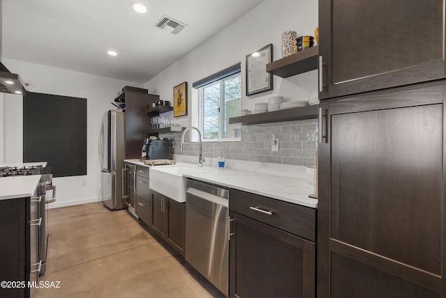 kitchen featuring open shelves, stainless steel appliances, a sink, dark brown cabinets, and recessed lighting