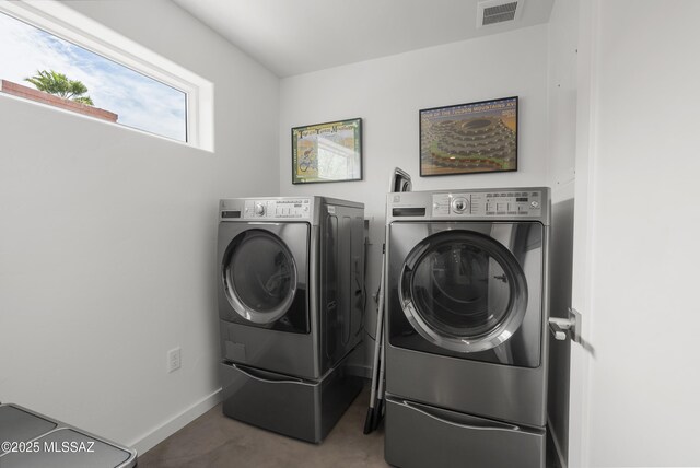 washroom with washer and dryer and baseboards