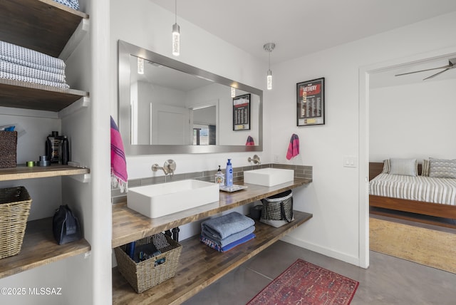 full bathroom with baseboards, ensuite bathroom, and double vanity