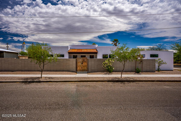 modern home featuring a fenced front yard, stucco siding, and a gate